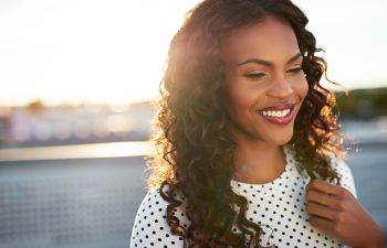 Beautiful cheerful Afro-American woman with long thick wavy hair.